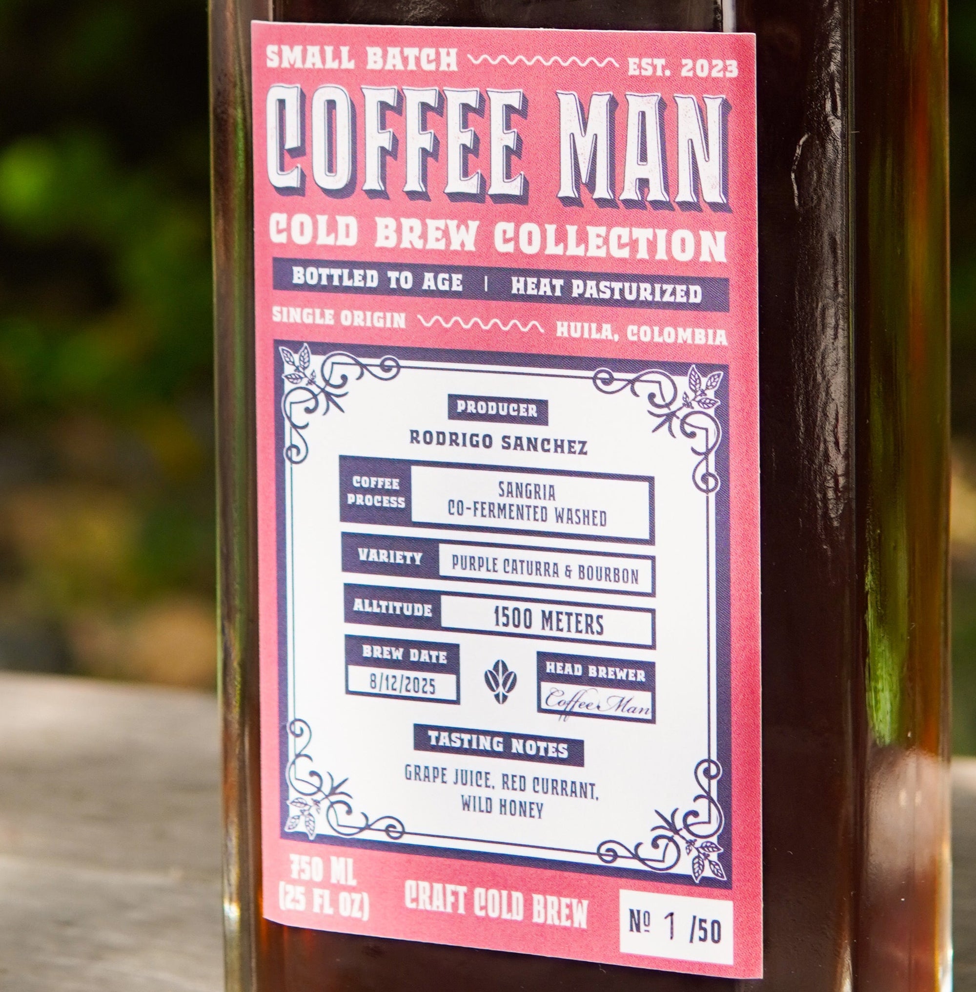 Glass bottle of Coffee Man cold brew collection on a wooden surface with a blurred green background