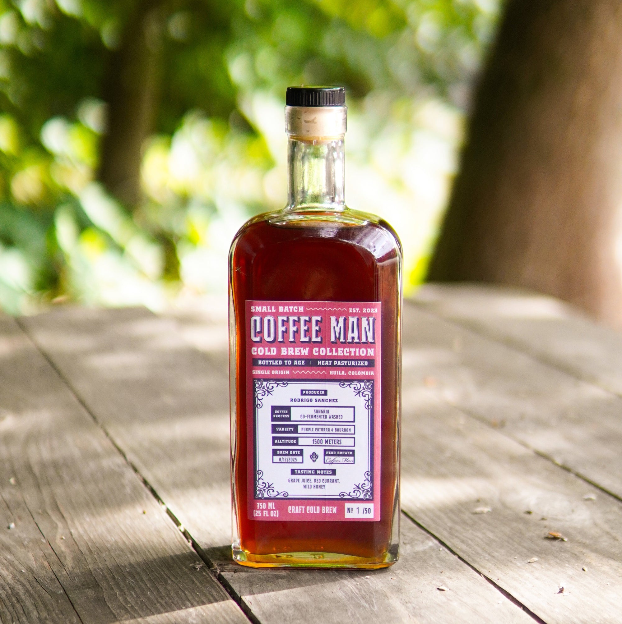 Bottle of Coffee Man cold brew on a wooden table with a blurred natural background