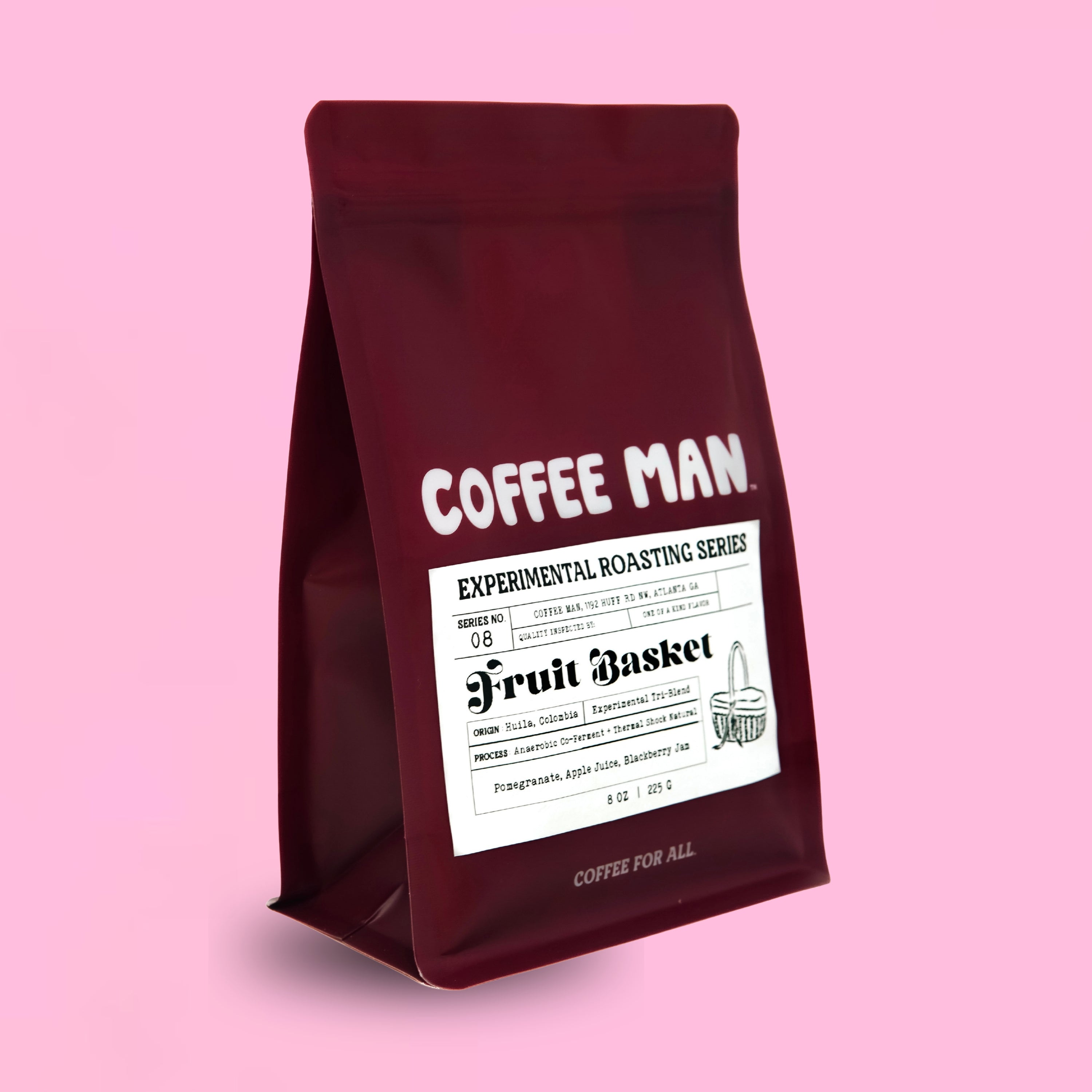 A dark red stand-up Colombian coffee bag with a white label reading 'COFFEE MAN' and 'Fruit Basket' on a solid pink background.