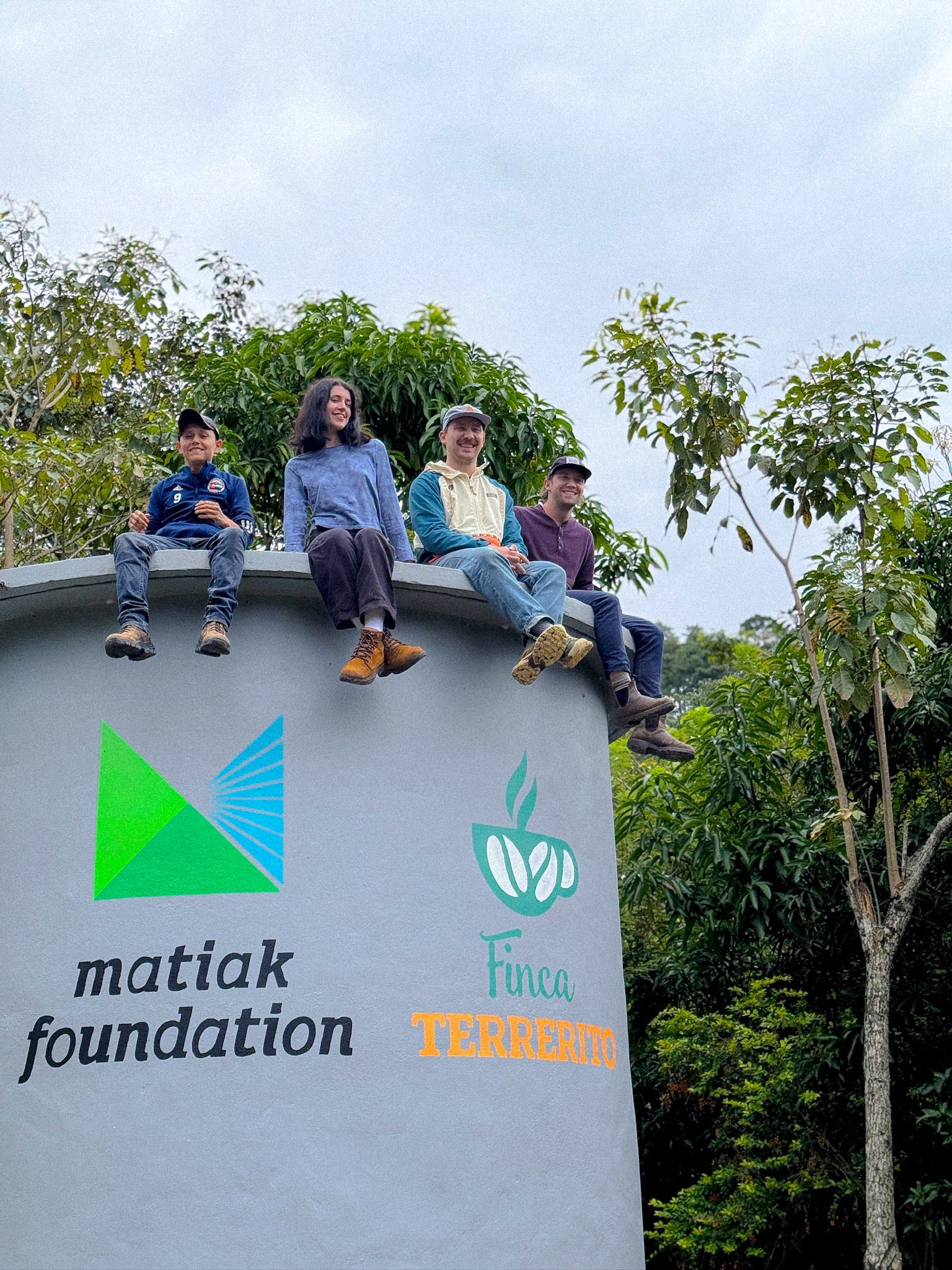 Coffee Man team and Finca Terrerito team sitting on Water Well dug for the community at Honduras Coffee Farm
